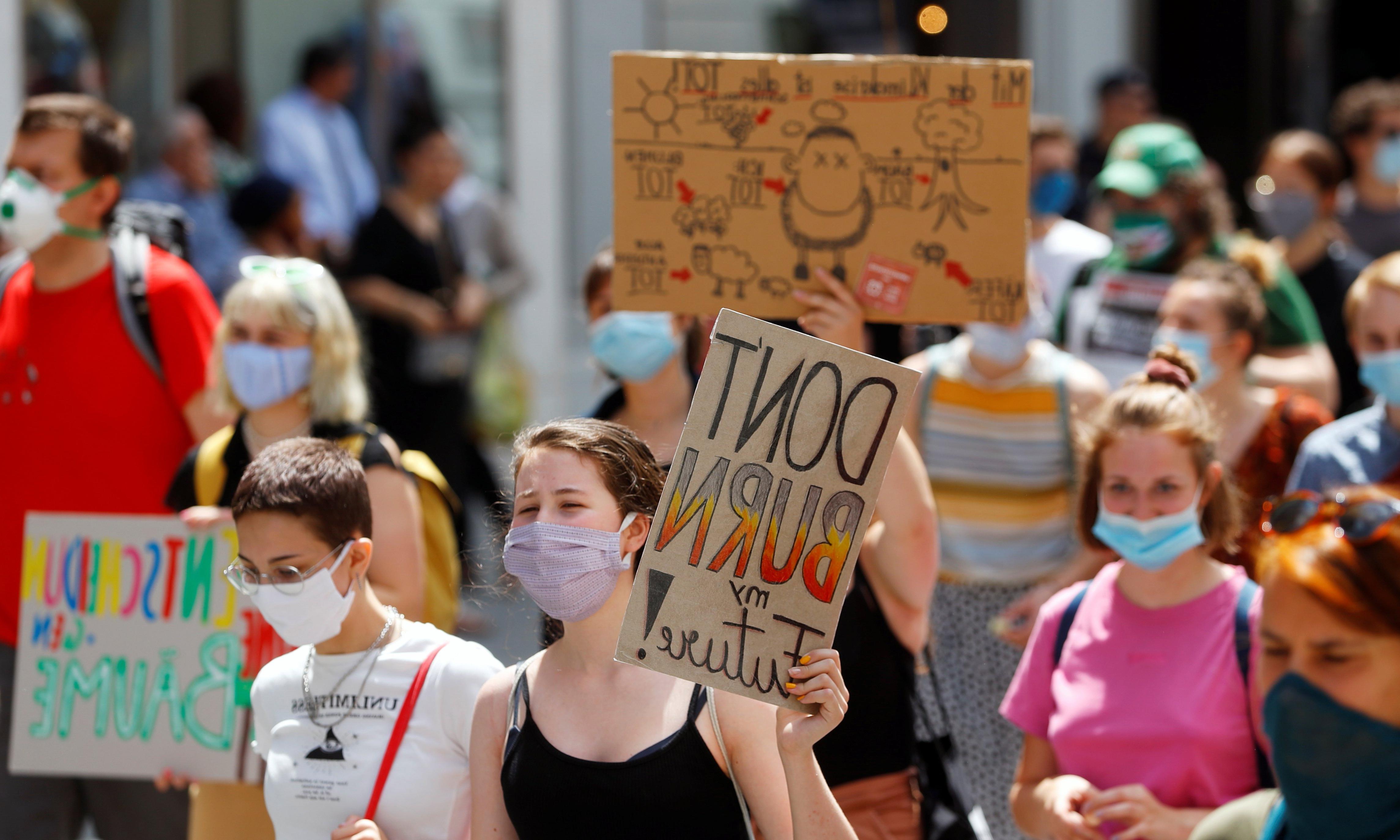 Climate change protester carries a sign that says 'Don't burn my future'