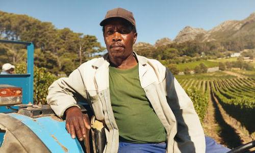 man on tractor in front of farm